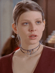 a close up of a woman wearing a choker and earrings