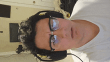 a man wearing glasses and headphones looks at the camera with a surprised look on his face
