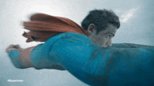 a man in a superman costume is flying in the sky