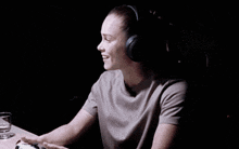 a woman wearing headphones is laughing in the dark .