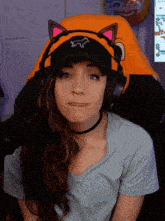 a woman wearing headphones and a hat with a cat on it
