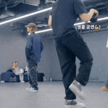 a man in a black shirt is standing on one leg in a room