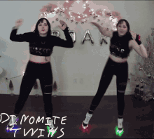 two women are dancing in front of a sign that says " dynamite twins " on it