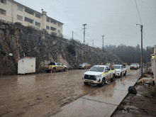 several trucks are parked on the side of the road