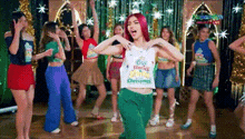 a woman with red hair is dancing with a group of women in a room .