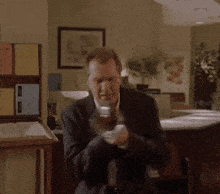 a man in a suit is standing in front of a counter and says whoa