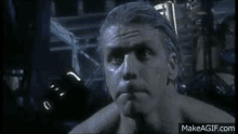 a shirtless man is standing in a dark room .