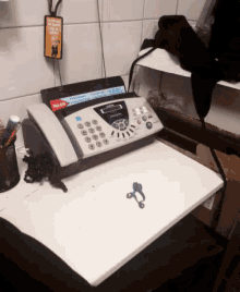 a fax machine is on a desk next to a sign that says boss