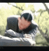 a man in a suit is laying on the ground with his head on his arms .