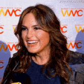 a woman is smiling in front of a wall that says wc