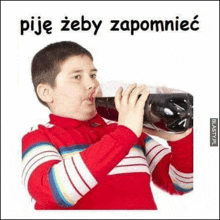 a young boy in a red shirt is drinking a bottle of soda .