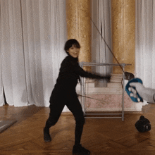 a woman is holding a sword and smiling in a room with columns