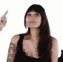 a woman with a tattoo on her arm is pointing to something
