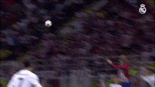 a soccer game is being played in front of a crowd with the real madrid logo on the screen