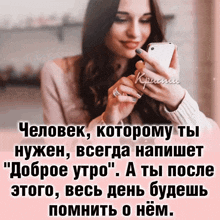 a woman is smiling while looking at her cell phone with a quote in russian