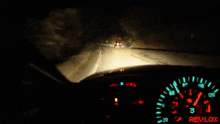 a person is driving a car at night and the speedometer shows that they are going very fast .