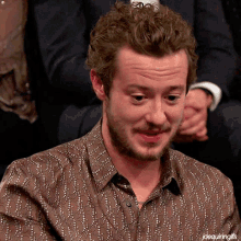 a man with a beard is wearing a brown shirt that says joequiringgifs on the bottom