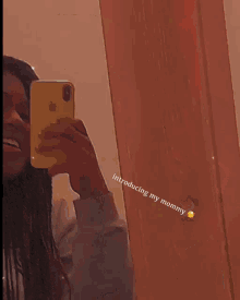 a woman taking a selfie with the words introducing my mommy written below her