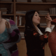 a woman in a red hat is clapping another woman 's hand