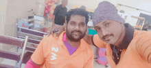 two men posing for a picture with one wearing a shirt that says 2m