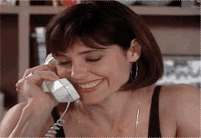 a woman is smiling while talking on the phone
