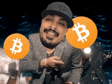 a man wearing a ny hat is holding two bitcoins