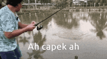 a man is fishing in a lake with ah capek ah written on the bottom of the image