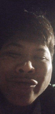 a close up of a person 's face with a dark background