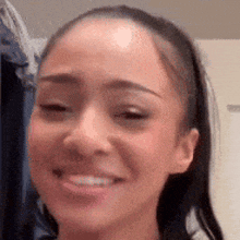 a woman is smiling and looking at the camera .