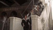 a group of men are walking down a set of stairs with graffiti on them