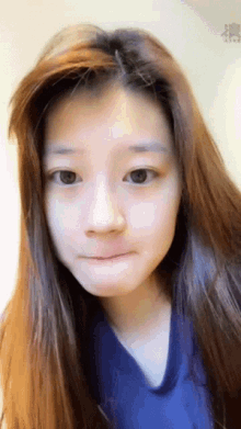 a close up of a woman 's face with a blue shirt on