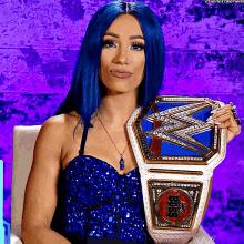 a woman with blue hair is holding a wrestling championship belt that says ' smackdown ' on it