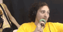 a man wearing headphones is holding a microphone in his mouth .