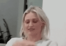 a woman is sitting on a couch with her eyes closed and making a funny face .