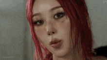 a woman with red hair is sticking her tongue out .