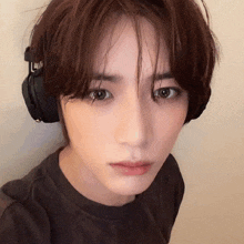 a close up of a person wearing headphones and looking at the camera