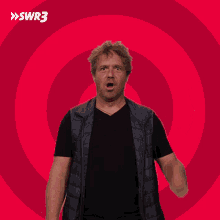 a man giving a thumbs up in front of a pink swirl with swr3 on it