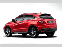 a red honda hrv is parked on a white surface
