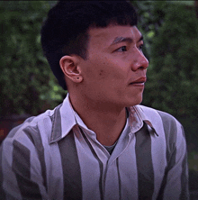 a man wearing a striped shirt with a white collar