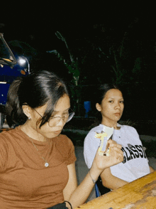 two girls are sitting at a table with one wearing a shirt that says classic