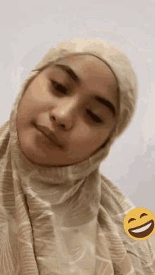 a close up of a woman wearing a hijab with a smiley face next to her