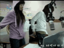 a woman in a purple hoodie is standing next to another woman in a white jacket