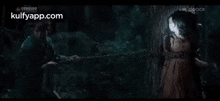 a man is holding a woman 's neck in a dark room in a movie .