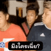 a man wearing an adidas shirt talks to another man
