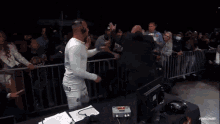 a man wearing a black shirt that says ' i am a man ' on it is dancing in front of a crowd