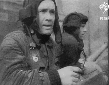 a black and white photo of a man wearing a helmet that says pathe on the bottom