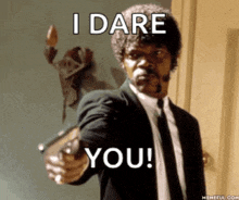 a man in a suit and tie pointing a gun with the words i dare you written below him