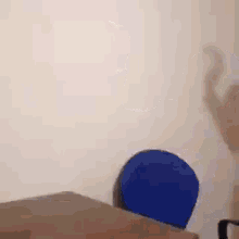 a blue balloon is sitting on top of a bed next to a white wall .