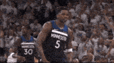 two minnesota basketball players number 5 and 30 stand on the court