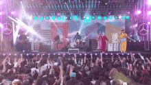 a crowd of people are watching a band on stage with a mercedes logo in the background